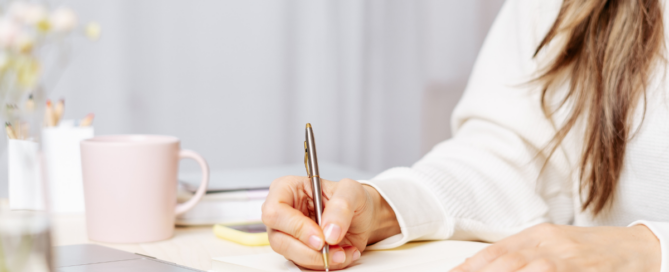 Our Commitment to Training and Certification in the Coatings Industry: Katherine’s Story - Woman writing on a notebook while looking at her laptop