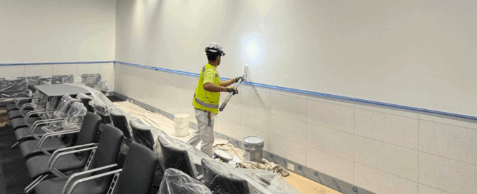 Fast-Track Projects: How We Deliver Under Tight Deadlines - Socium Coatings' painter painting with a roller the wall of an airport