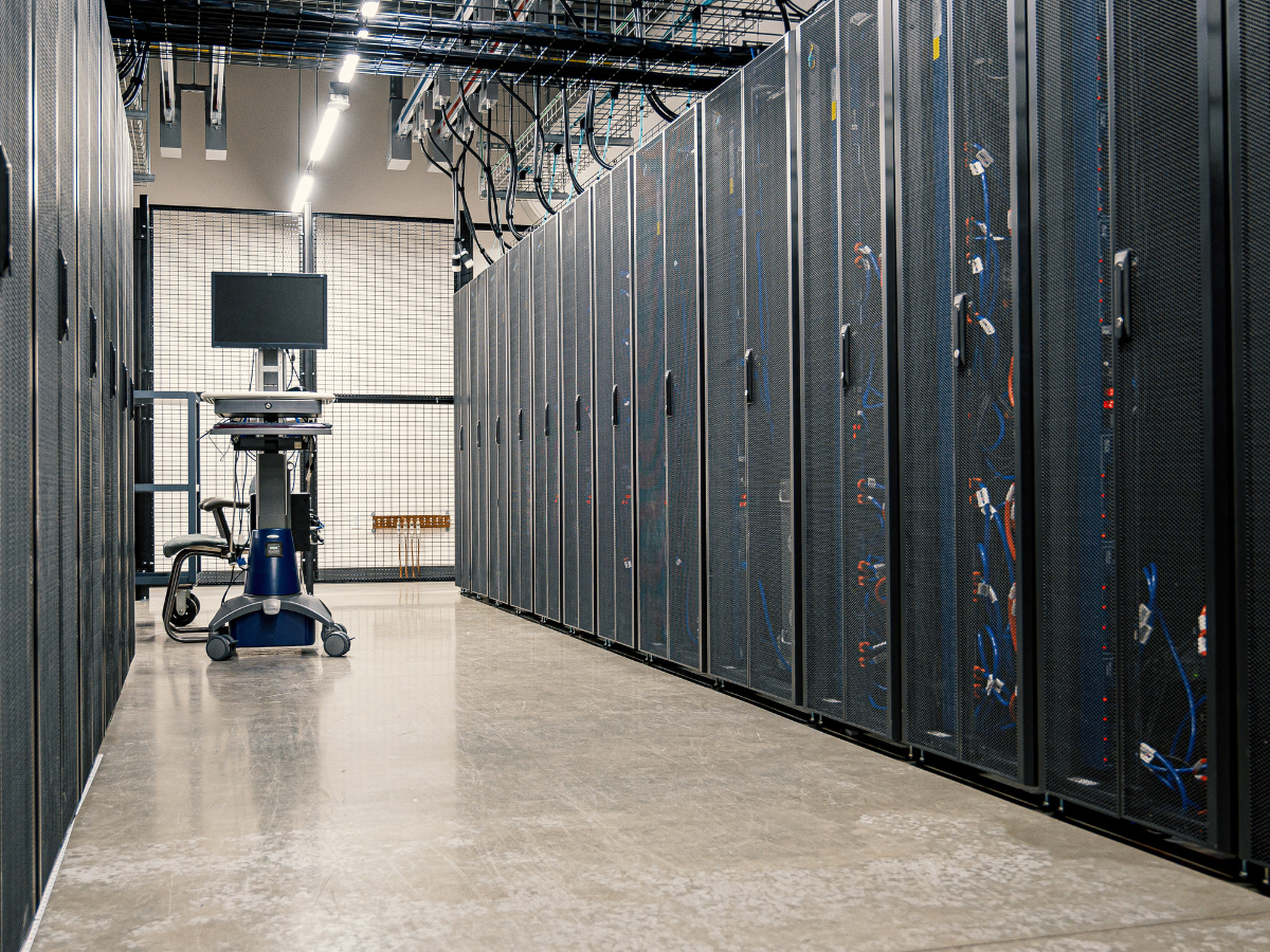 Interior of a data center room with servers, racks, organized cables, and cooling systems.