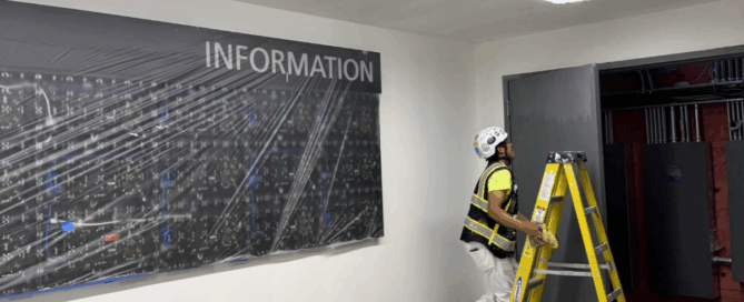 The True Cost of Cutting Corners in Coatings Projects - Painter climbing ladder in the interior of the airport