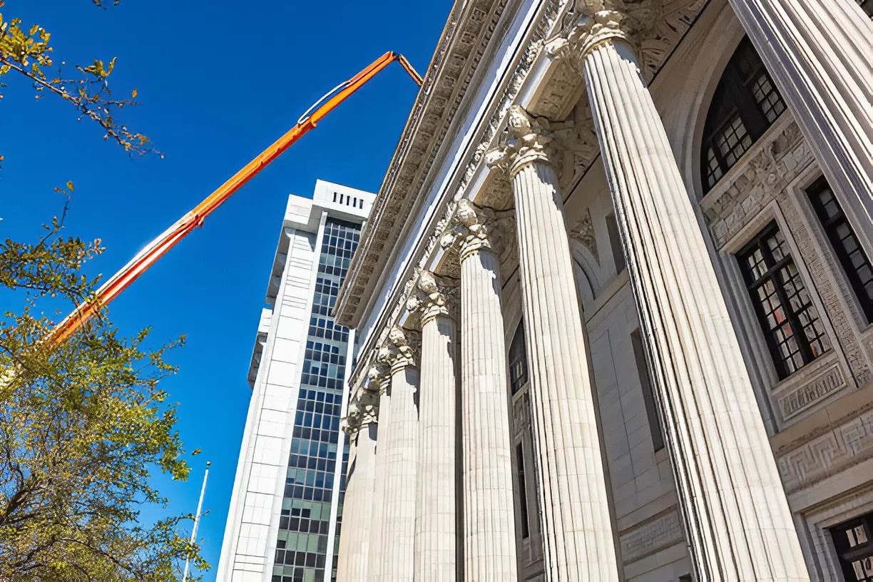 Government painting contractor in Atlanta using a boom lift to work on the exterior of a large federal building
