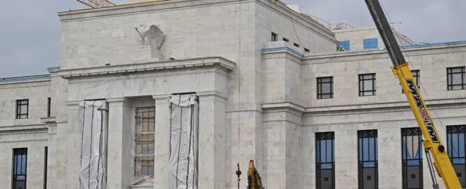 Government painting contractor in Atlanta using a boom lift to work on the exterior of a large federal building