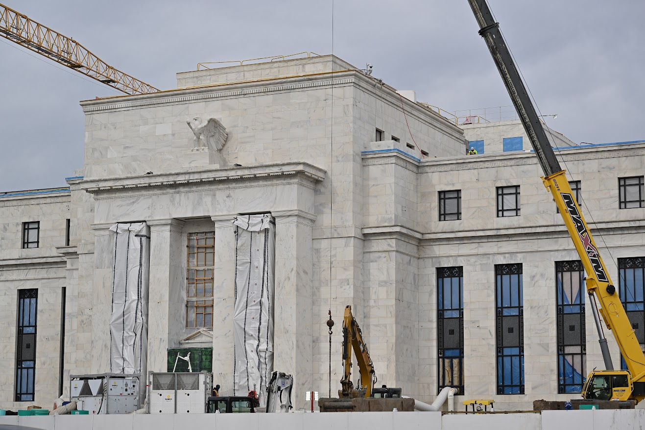 Government painting contractor in Atlanta using a boom lift to work on the exterior of a large federal building