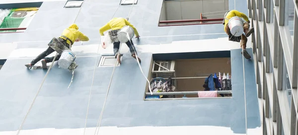 Professionals of a commercial painting company painting a building exterior