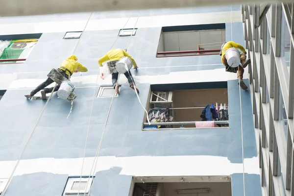 Professionals of a commercial painting company painting a building exterior
