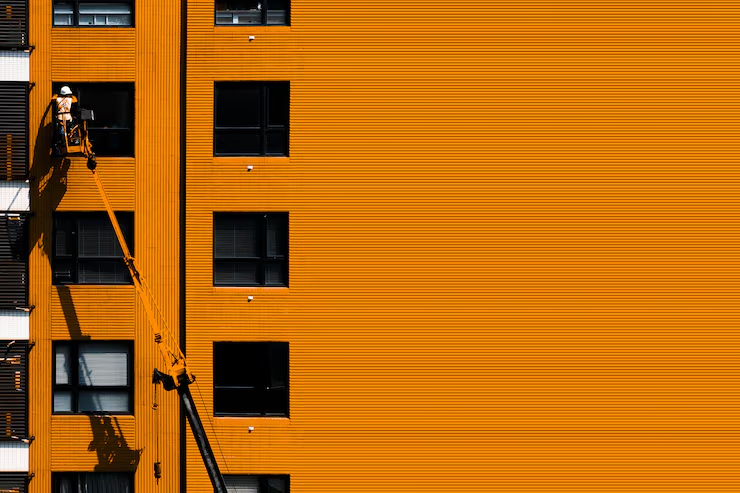 Commercial painter applying a bold color to a building exterior