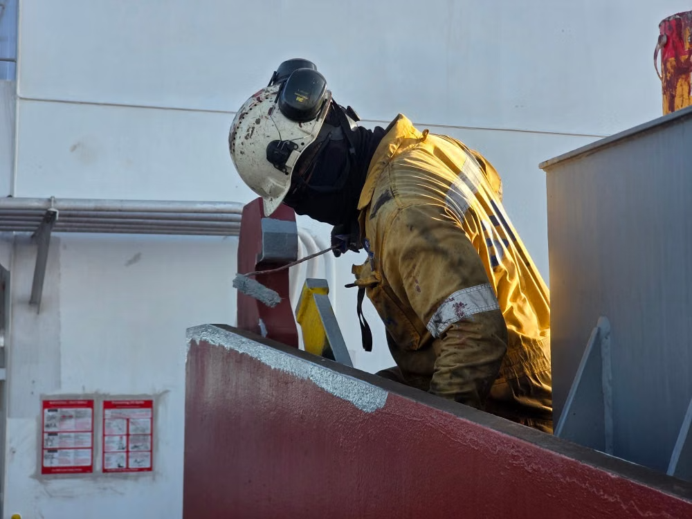 Professional painter painting the exterior of a manufacturing facility