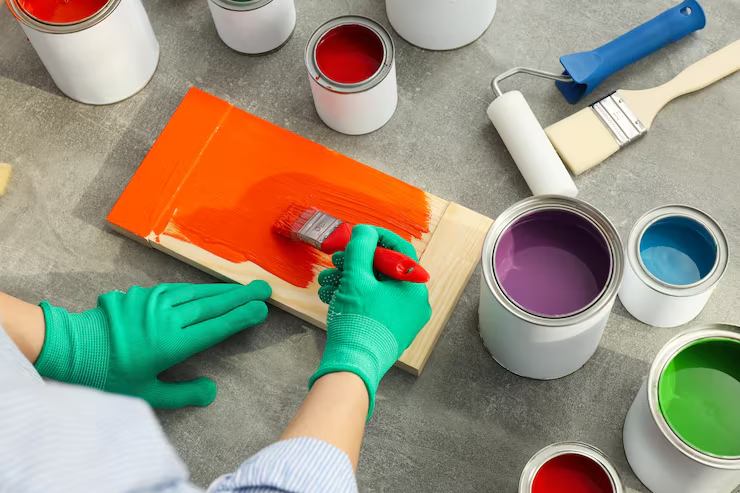 Painter swatching paint color on a wooden surface