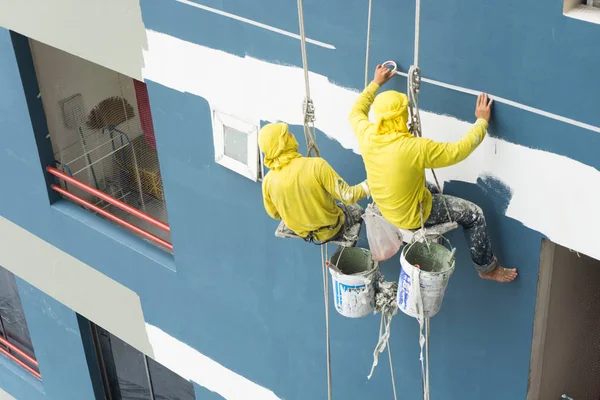 Commercial building exterior being painted by professionals